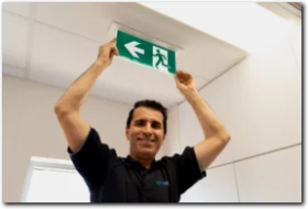 Technician performing electrical testing and tagging on workplace equipment